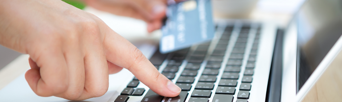 Hand with credit card and laptop
